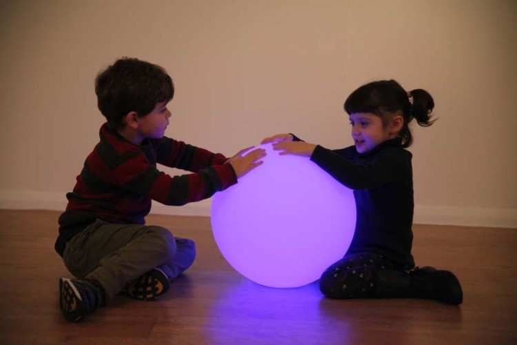 Kula sensoryczna LED 40 cm włączona w ciemnym pomieszczeniu, równomiernie rozprowadzające kolorowe światło