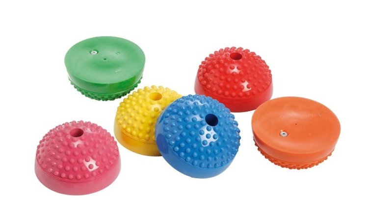 Kolorowe półkule sensoryczne Gymnic Multiactiv Stones ułożone w tor ćwiczeń, widok z boku