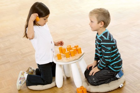 Zbliżenie na pomarańczowy shaker z gry pamięciowej Shake'n'Play wykonany z drewna kauczukowego