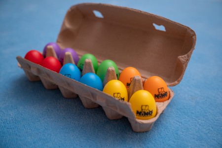 Kolorowe plastikowe jajka-shakery ułożone w wytłaczance o wymiarach 30 na 11,8 cm