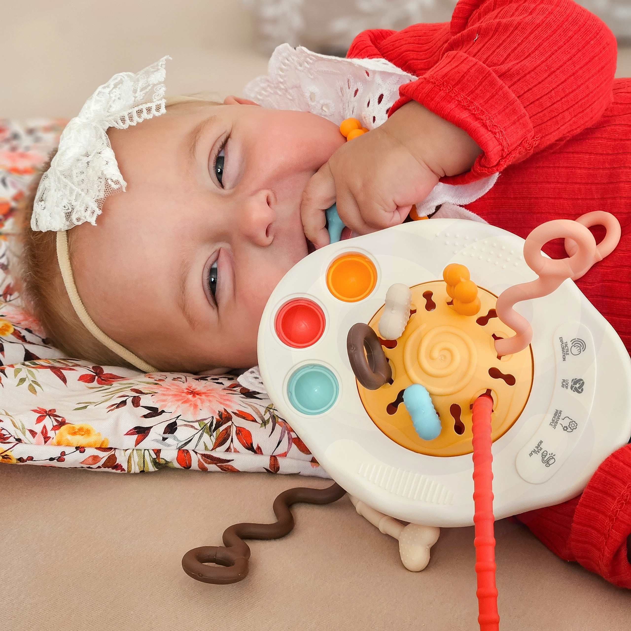 Kolorowa zabawka sensoryczna Woopie Baby z miękkimi guzikami i sznurkami o różnych fakturach